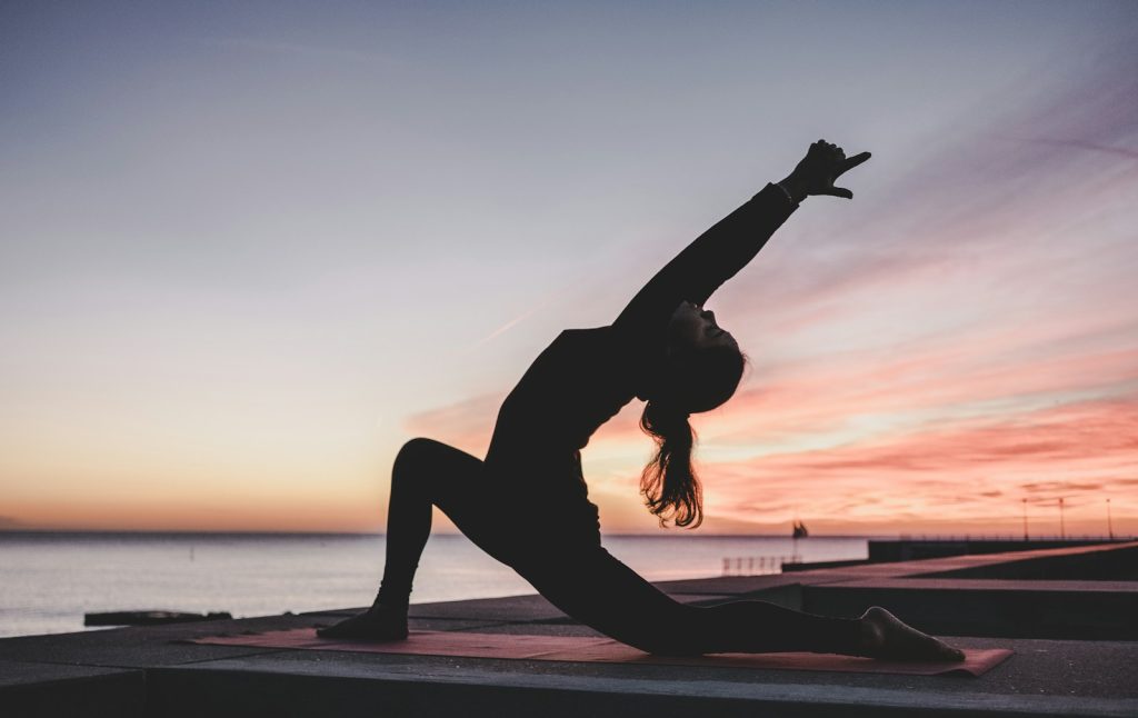 silhouette photography of woman doing yoga, a form of self-care for women