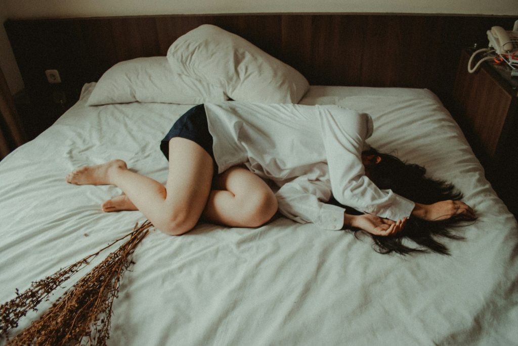 woman lying on bed, when self-care isn't helpful
