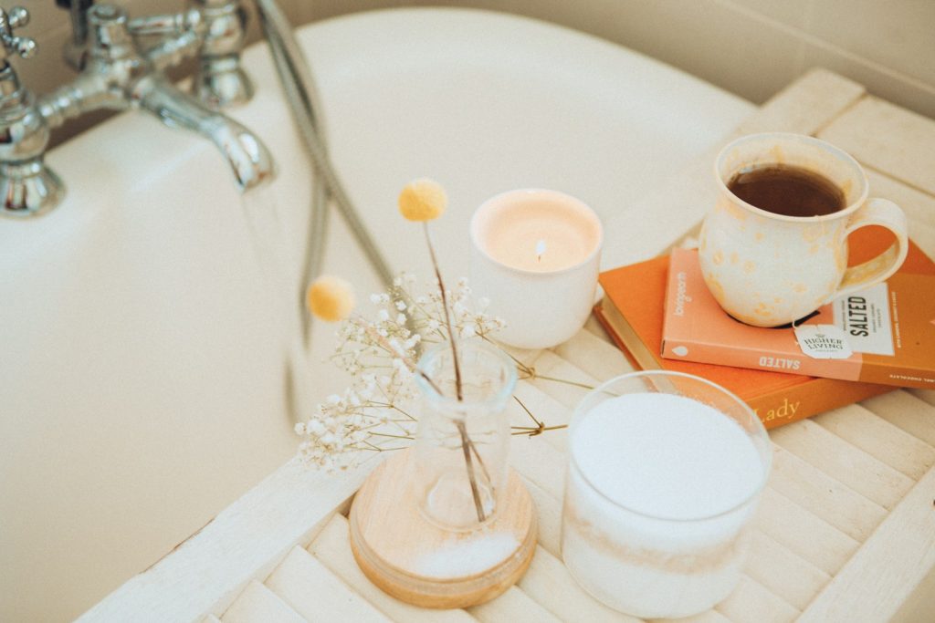 a cup of coffee and some books on a bathtub, best self-care ideas