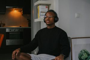 a man sitting in a chair wearing headphones, meditating for a corporate wellness program