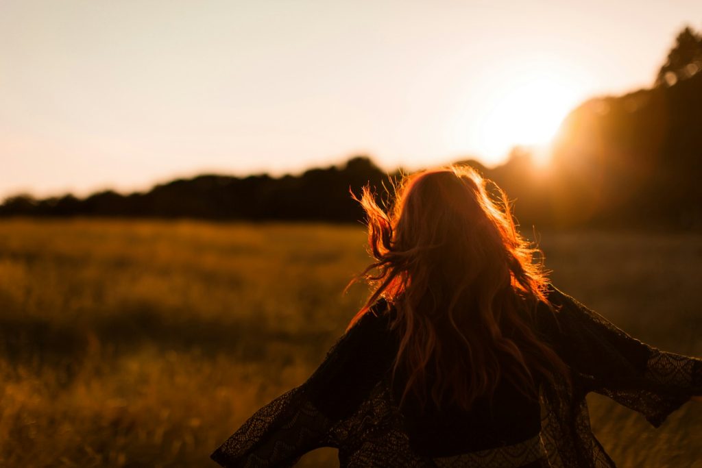 woman standing on grass field symbolizing freedom 