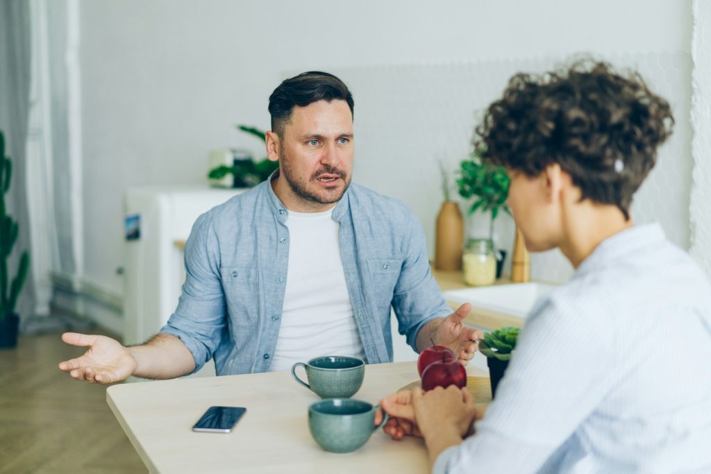 a man sitting at a table talking to a woman he appears angry. on a blog about signs someone has borderline personality disorder