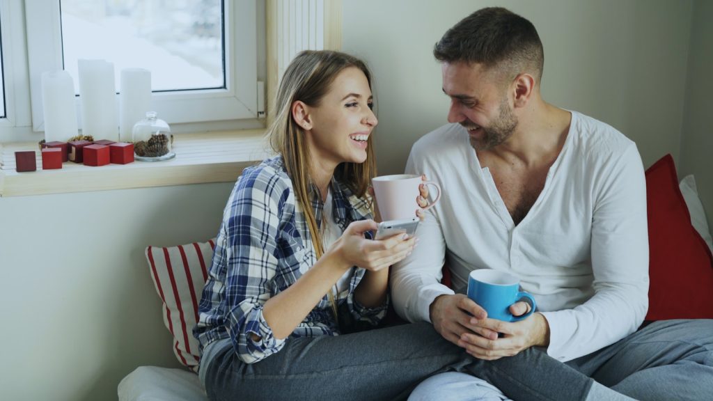 Couple enjoying coffee together by the window enjoying healthy communication